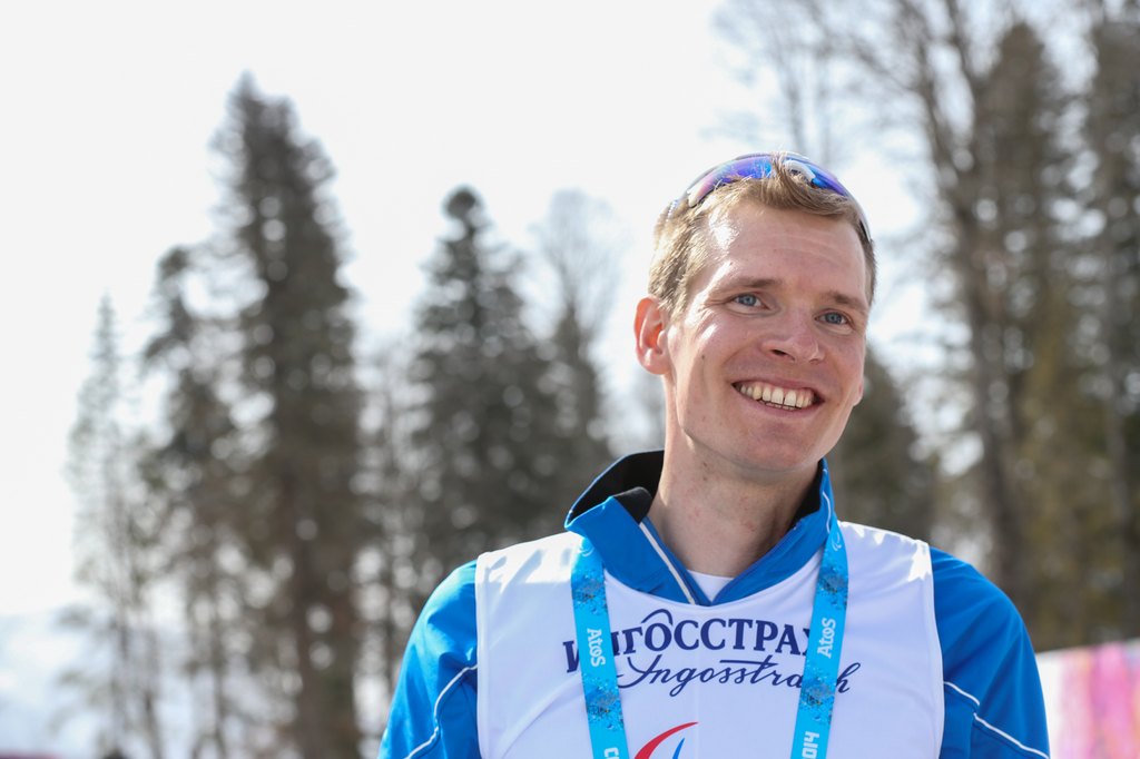 Ilkka Tuomisto hymyilemässä mitali kaulassaan, lähikuva.